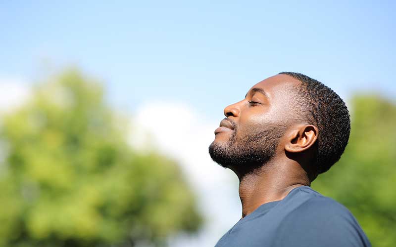 A man enjoys sunshine on his face.