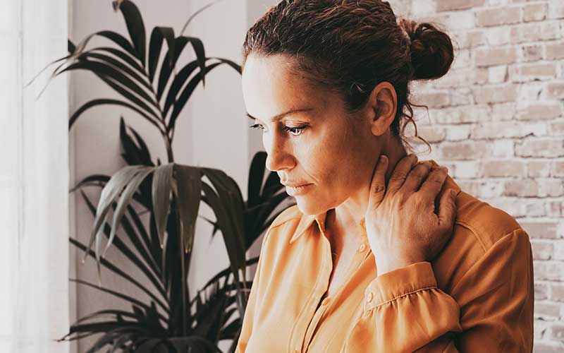 A woman is depressed and gazes out a window. She feels isolated and stuck.