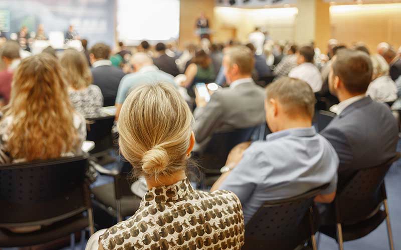 A large audience enjoys an interactive conference presentation.